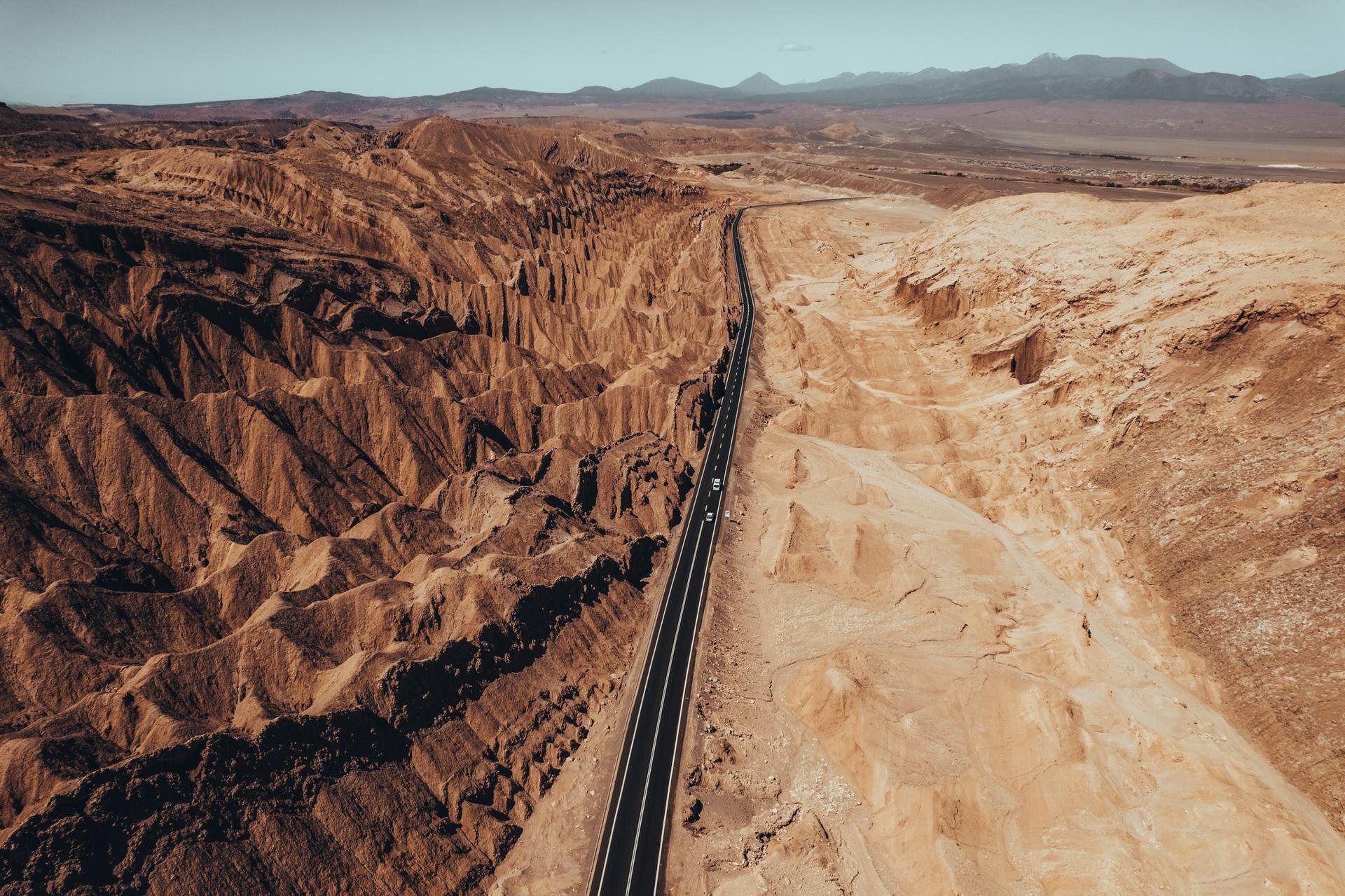 Vista aérea de una carretera atravesando un paisaje desértico entre cerros